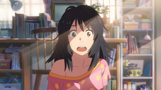 A shocked girl with black hair in a pink polka dot shirt in a cozy room with books and sunlight