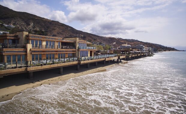 Luxury houses on the Malibu California coastline beside the ocean waves