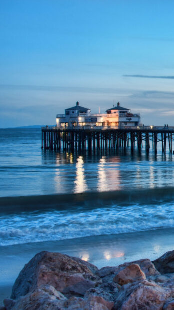 Malibu California pier with calm ocean waves at dusk in Malibu California