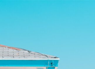 A lifeguard tower in Malibu California stands on the sandy beach under a clear blue sky