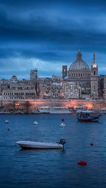 Evening view of Malta historical cityscape with boats on the water