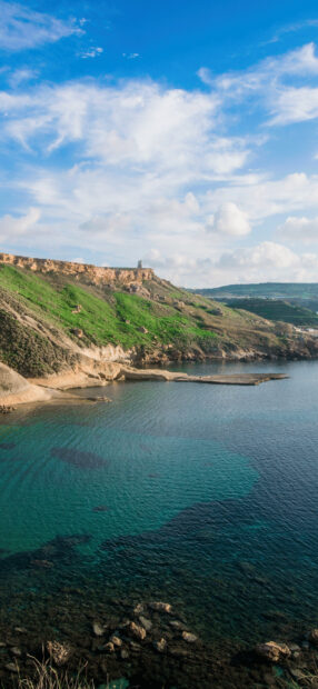 A stunning coastal landscape with clear turquoise waters and green cliffs in Malta
