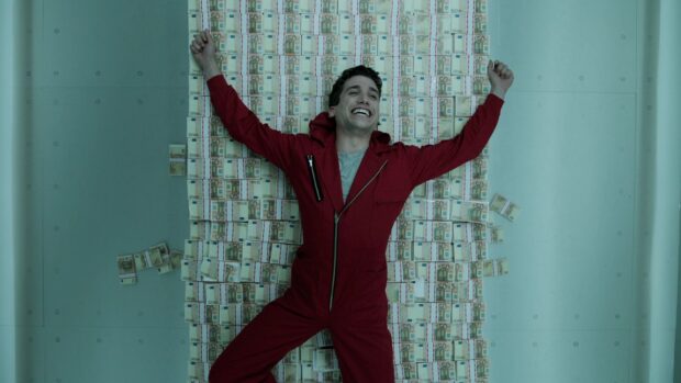 A man in a red suit happily lying on stacks of money in Money Heist Wallpapers, HD Desktop Wallpaper