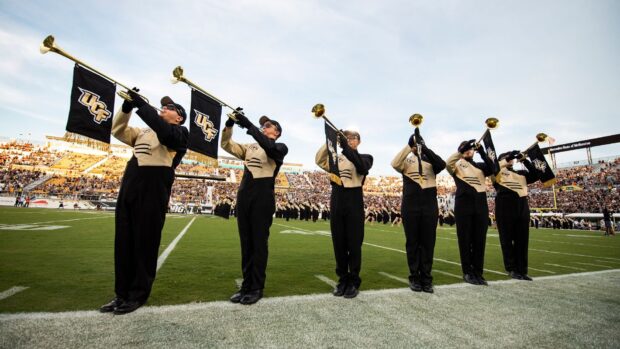 Musicians in marching band performing on a green field during a football game, HD Desktop Wallpaper