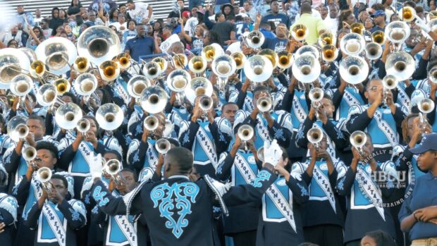 A marching band plays brass instruments in a lively stadium crowd, HD Desktop Wallpaper