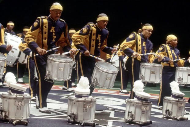 A marching band is performing on a field wearing yellow and blue uniforms, HD Desktop Wallpaper