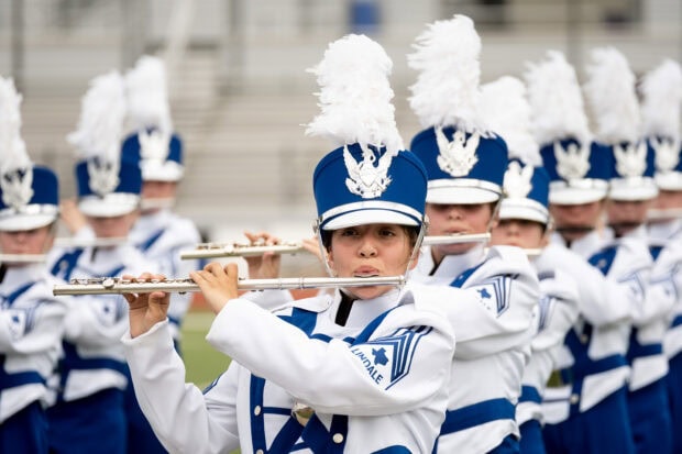 A marching band performing with flutes in blue and white uniforms during a field event, HD Desktop Wallpaper