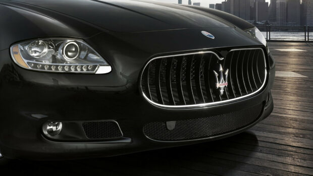 Close up view of Maserati luxury car front grille and headlight on wooden pier