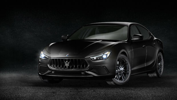 A sleek black Maserati luxury car front view in high resolution with glowing headlights