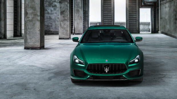 Green Maserati car front view inside an industrial building interior