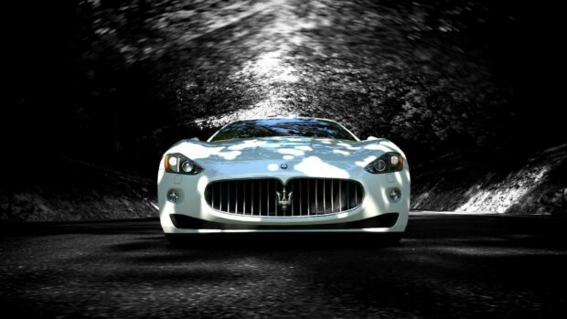 White Maserati sports car front view with sunlight reflections on a dark road