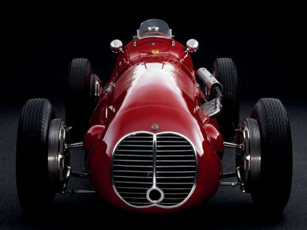 Red Maserati vintage racing car front view with grille and wheels on black background