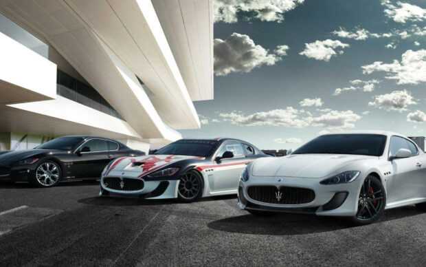 Three luxury Maserati cars parked in front of a modern building showcasing Maserati design