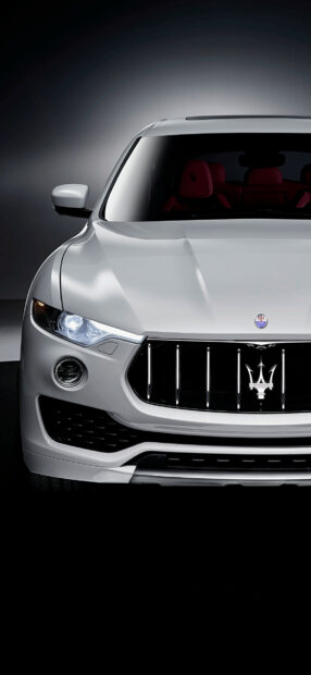 White Maserati front view with luxury red interior and illuminated headlight