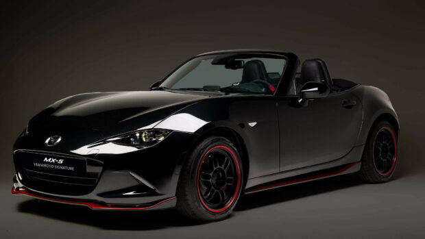 A sleek black Mazda MX 5 convertible car with red accents is displayed on a dark background, 4K Desktop Wallpaper