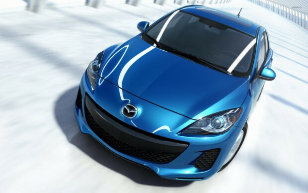 A blue Mazda car is shown from the front with detailed headlights and grille, HD Desktop Wallpaper