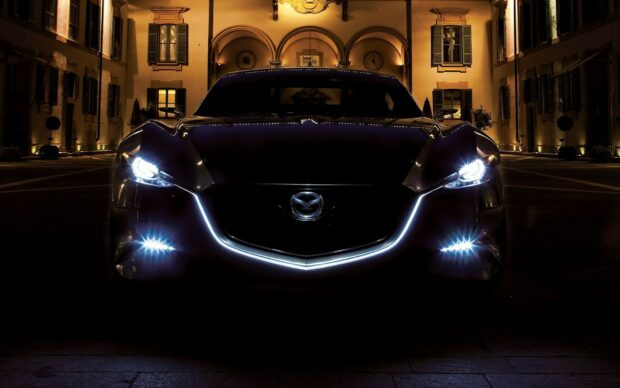 A black Mazda car with glowing headlights is parked in an elegant courtyard at night, HD Desktop Wallpaper