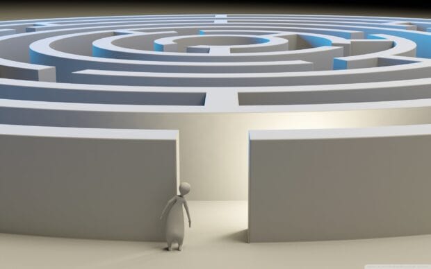 A person figure standing at the entrance of a complex maze structure with circular pathways