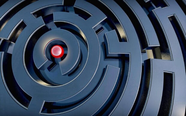 A close up of a circular maze with a red sphere at the center highlighting the maze design