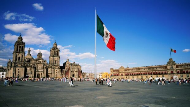 The Mexico City flag waves over the historic plaza filled with people and buildings, HD Desktop Wallpaper