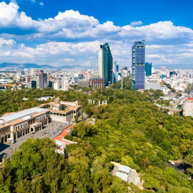 The Mexico City skyline features tall buildings and lush parks under a blue sky, HD Desktop Wallpaper