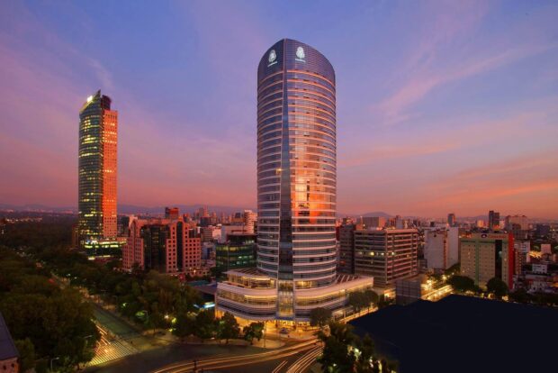 The Mexico City skyline shows modern skyscrapers glowing at sunset with a colorful sky, HD Desktop Wallpaper