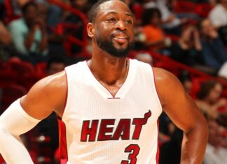 Dwyane Wade smiling on the court in a Miami Heat jersey during a game