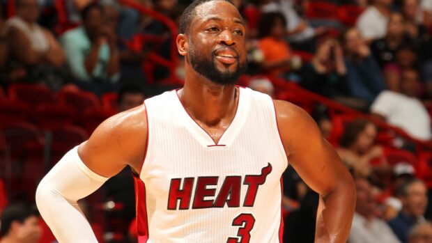 Dwyane Wade smiling on the court in a Miami Heat jersey during a game