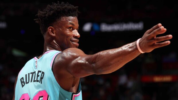Jimmy Butler smiling during a Miami Heat game in a teal jersey