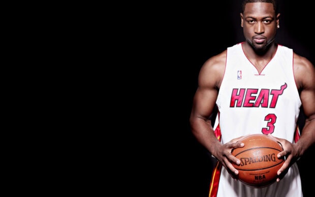 Miami Heat player holding a basketball wearing a white jersey with number 3 on a black background