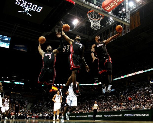 Miami Heat players jumping for a basketball during a game in an indoor stadium