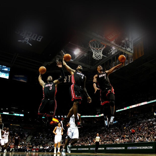 Miami Heat players performing dunks during a basketball game in an NBA arena