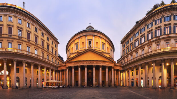 The historic San Carlo building in Milan with grand columns and evening lights