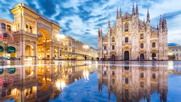 The famous Milan cathedral and arch reflecting in the wet square on a cloudy day