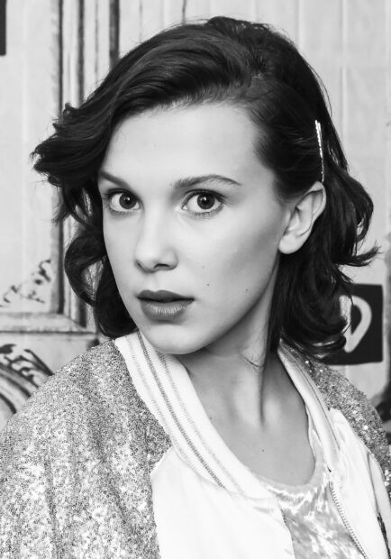 Millie Bobby Brown looks directly at the camera in a black and white photo, HD Mobile Wallpaper