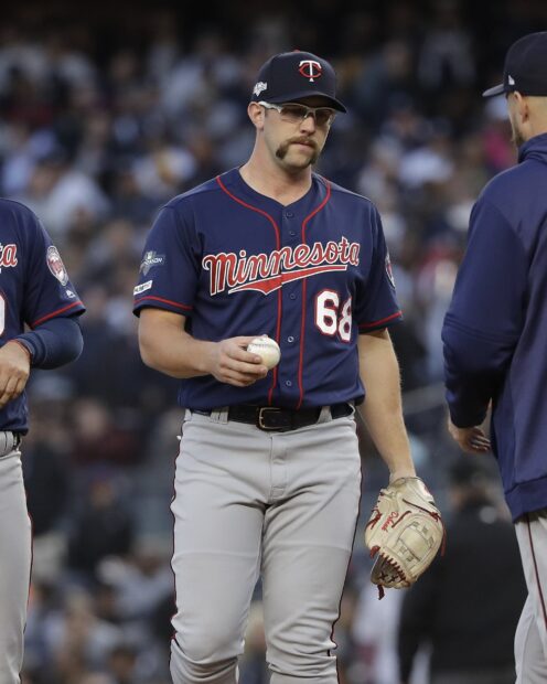 A Minnesota Twins player holding a baseball and wearing the team uniform during a game, HD Mobile Wallpaper