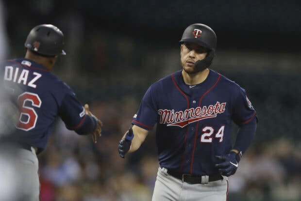 Two Minnesota Twins players celebrating a play on the field during a night game, HD Desktop Wallpaper