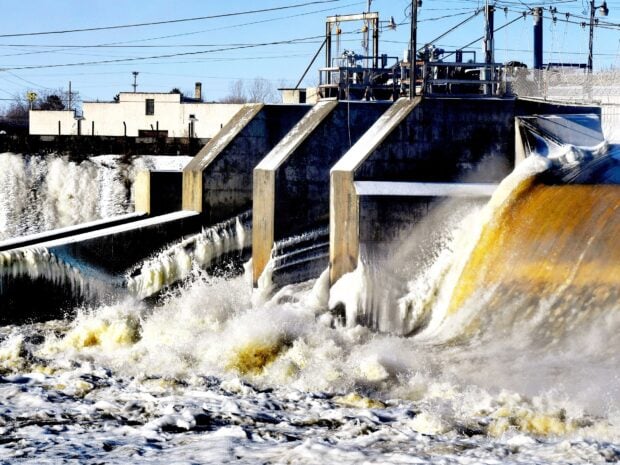 The Mississippi River shows water rushing over a dam under a clear blue sky, HD Desktop Wallpaper