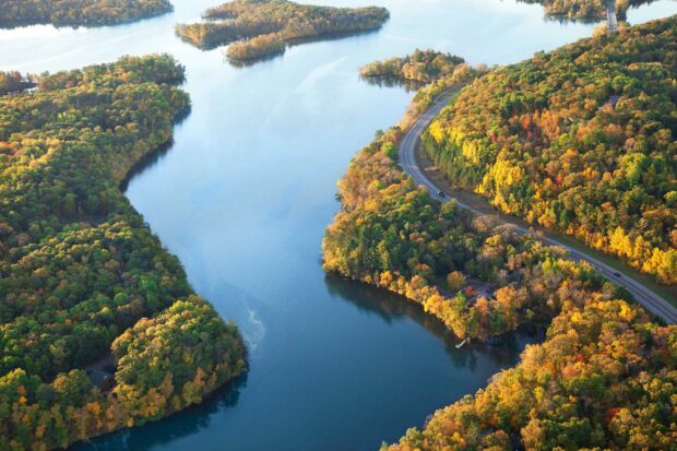 The Mississippi River flows through the colorful autumn forest with a winding road alongside, Desktop Wallpaper