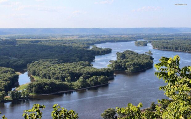 The Mississippi River flows through dense green forests under a clear sky, HD Desktop Wallpaper