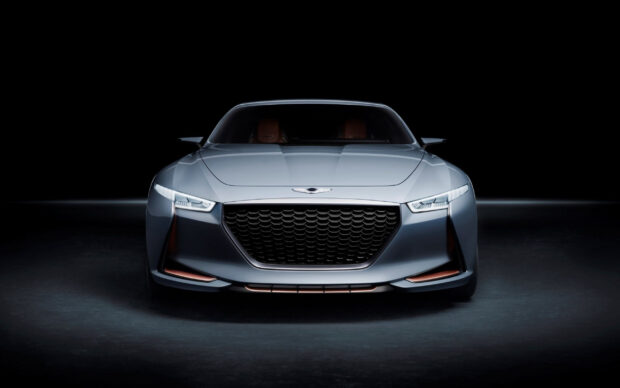 A sleek silver Genesis car is showcased from the front with bright headlights, 2K Desktop Wallpaper