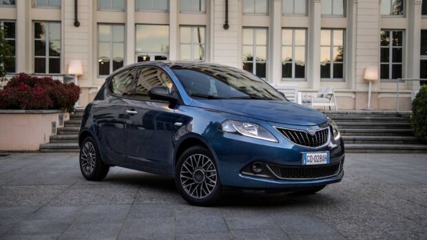 A blue Lancia is parked outside a building with large windows and stairs, HD Desktop Wallpaper