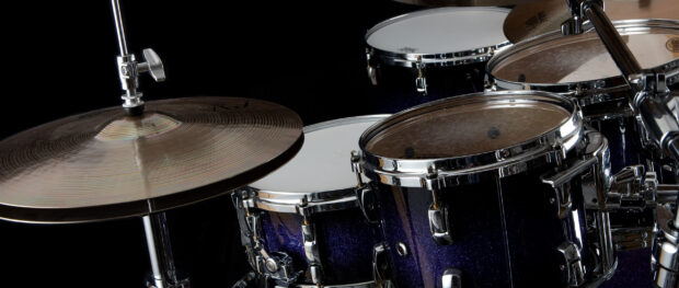 A close up of drums showcasing a sparkling finish and cymbals in a dark studio, 2K Desktop Wallpaper