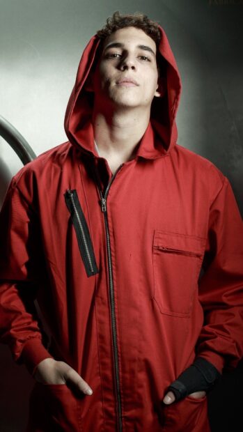 A man wearing a red jumpsuit stands confidently with his hands in pockets and a hood up, 4K Phone Wallpaper