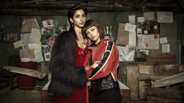 Two women from Money Heist stand closely in a secret hideout filled with maps and notes, 4K Desktop Wallpaper