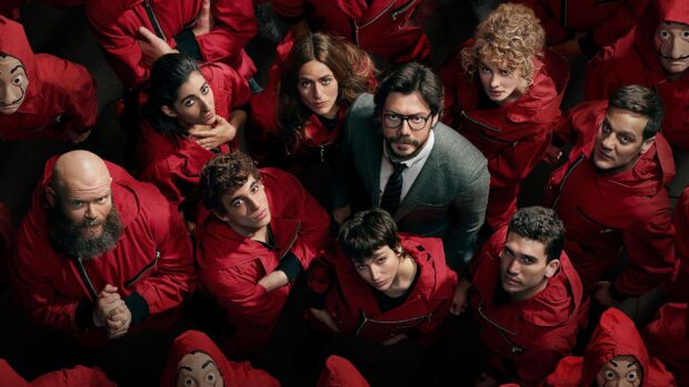 The Money Heist group is gathered and looking up wearing iconic red suits and masks, 2K Desktop Wallpaper