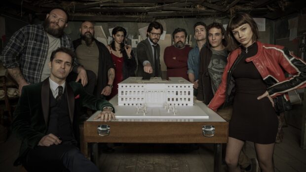The Money Heist characters stand around a table with a building model in a dimly lit room, HD Desktop Wallpaper
