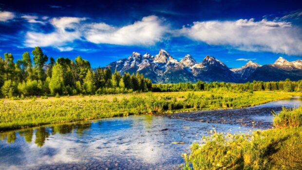 A clear river flows in front of the Montana mountain range under a blue sky, 4K Desktop Wallpaper