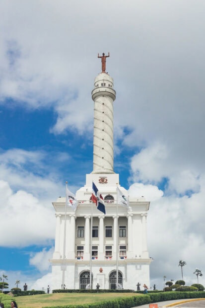 The monument with Dominican Republic flags stands tall beneath a blue sky, HD Mobile Wallpaper