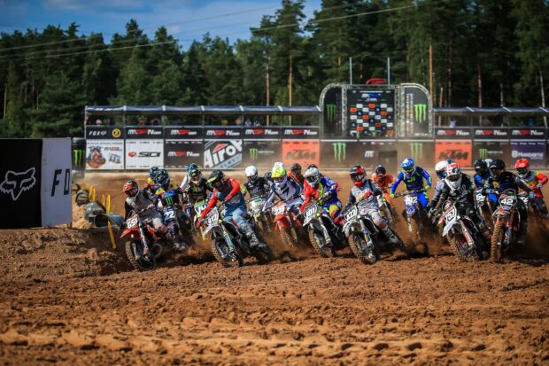 A group of motocross riders compete on a dirt track kicking up dust, HD Desktop Wallpaper